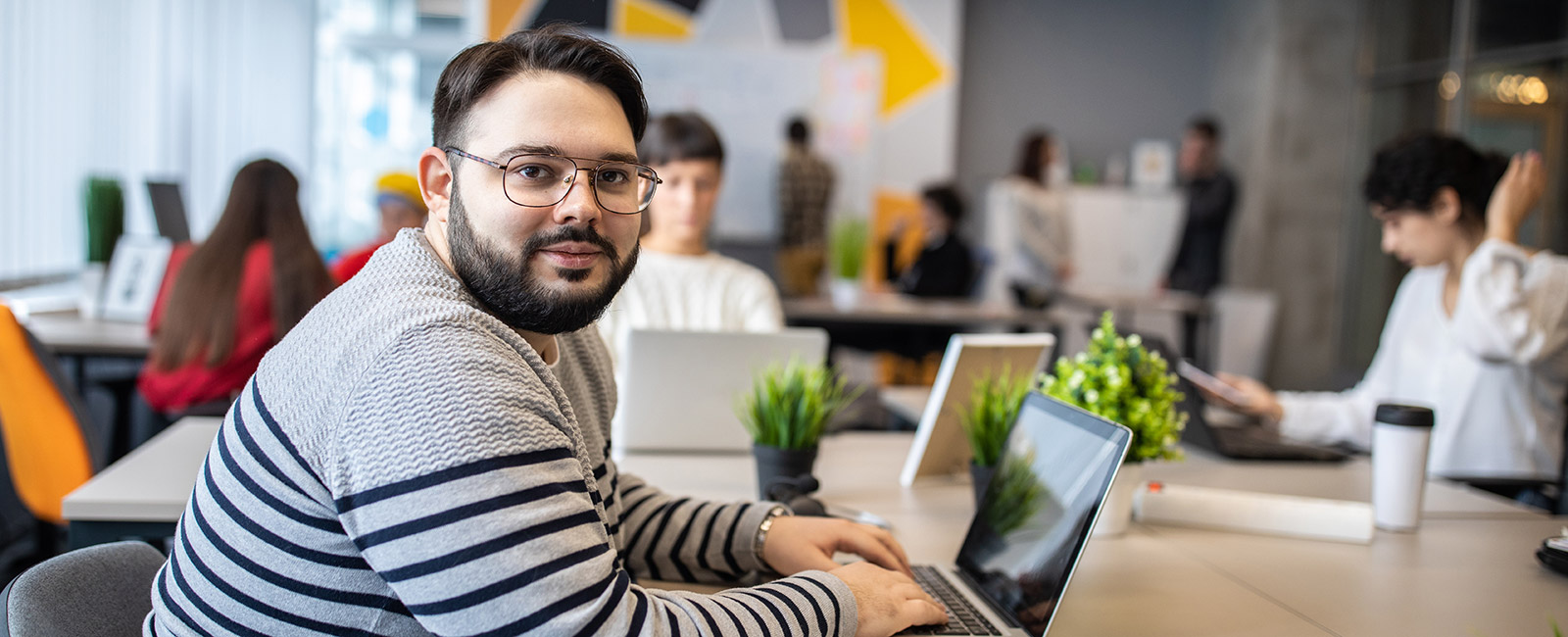 A man at his laptop at work wondering what causes obesity